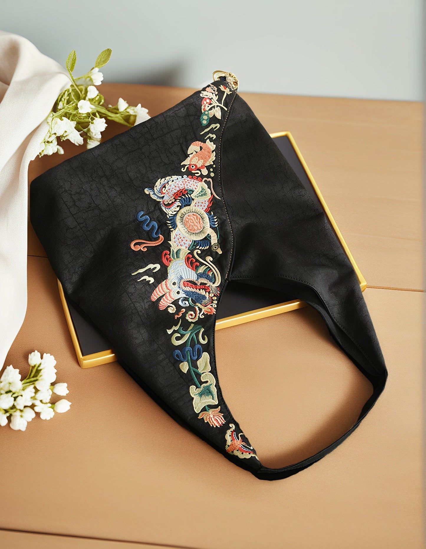 Top view of the Loong Li Xiangyunsha shoulder bag, showcasing its deep, naturally unique Xiangyunsha texture and the ​luxurious, exquisite hand-embroidered​ "Carp Leaping Over the Dragon Gate" motif.It shimmers with a charming luster under different lighting conditions.